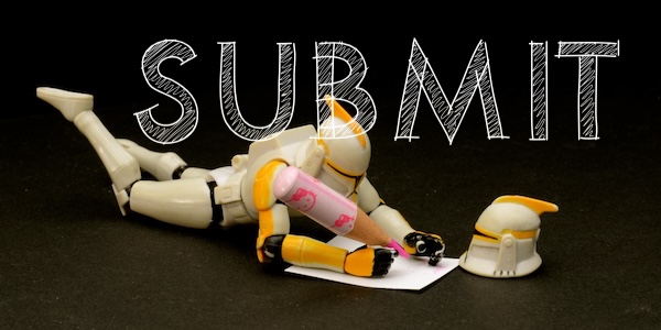 Action figure laying down writing with a large pencil.
